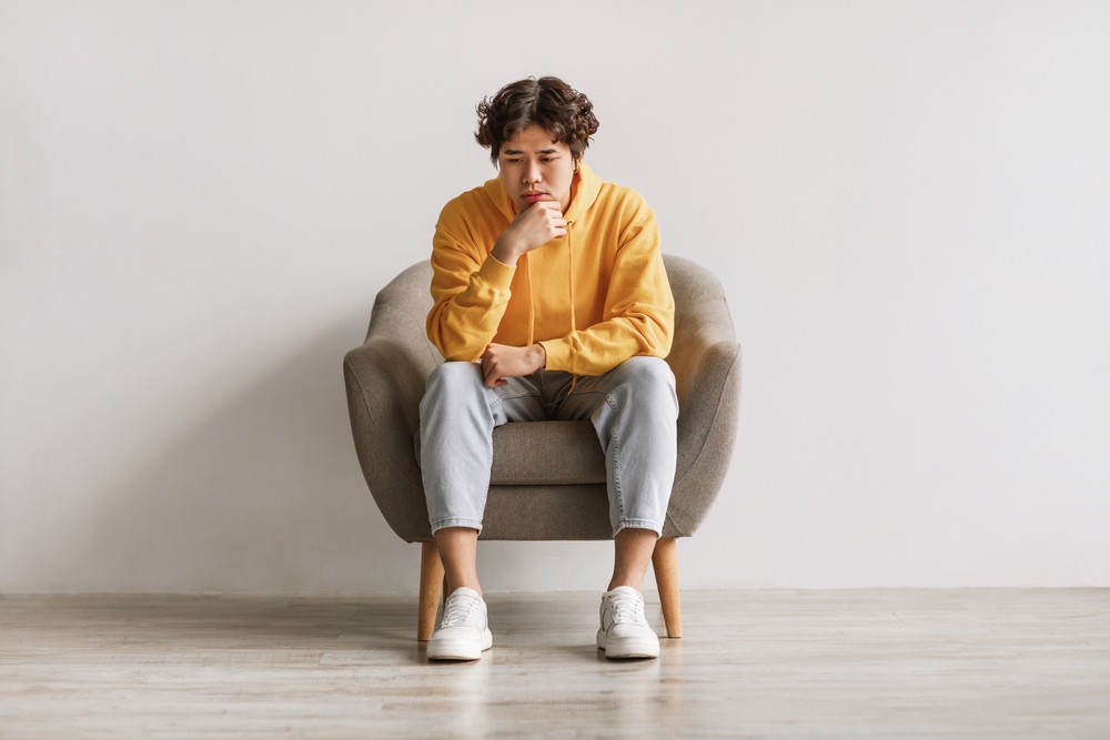 young man sitting worried in a chair
