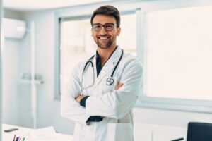 male doctor smiling and standing in a office